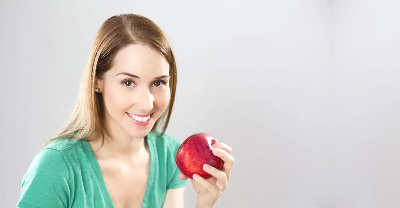 Manuela Contis, nutrizionista, con una mela rossa